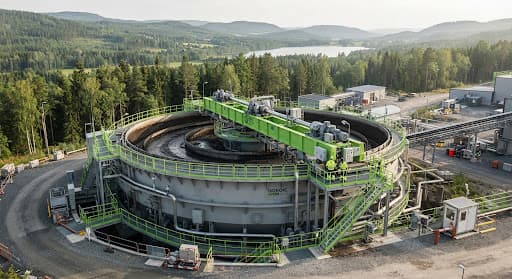 Nordic Green branded high-rate thickener with lime-green bridge railings in a forested landscape